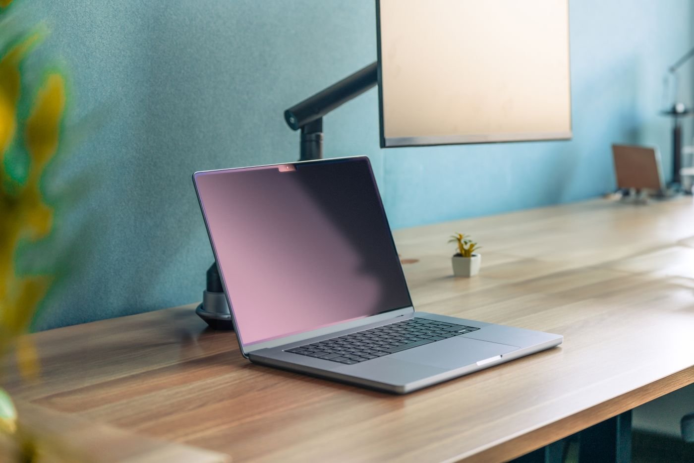Laptop open on a wooden desk in a calm workspace