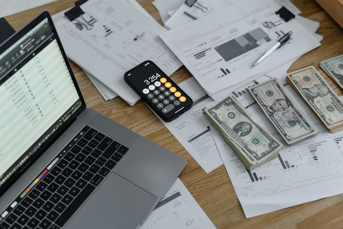 Banknotes and a calculator on a table, representing IT cost comparison
