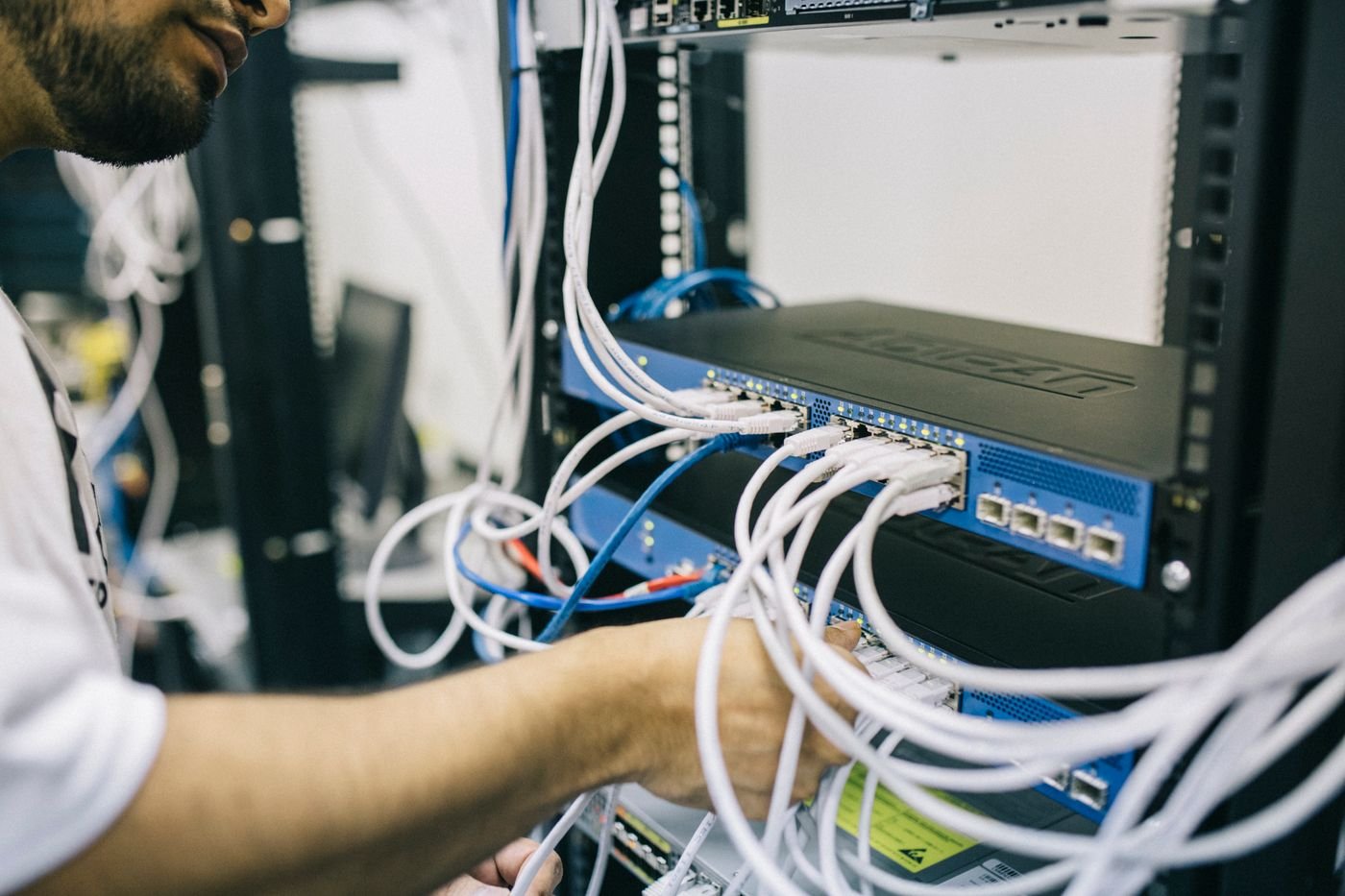 IT professional configuring Ethernet cables in a network rack
