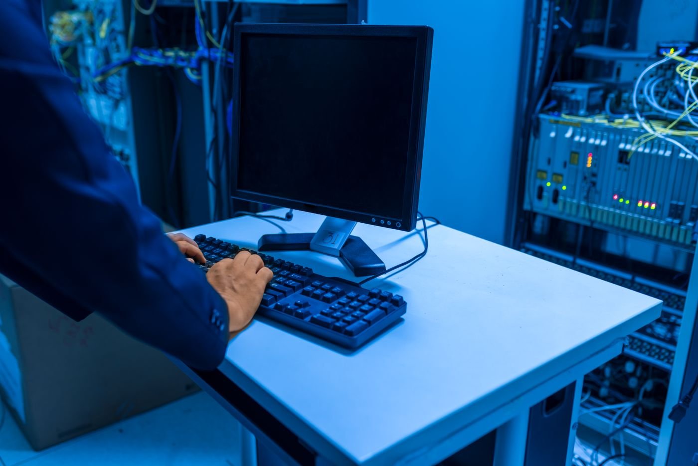 IT technician working among server racks in a data center